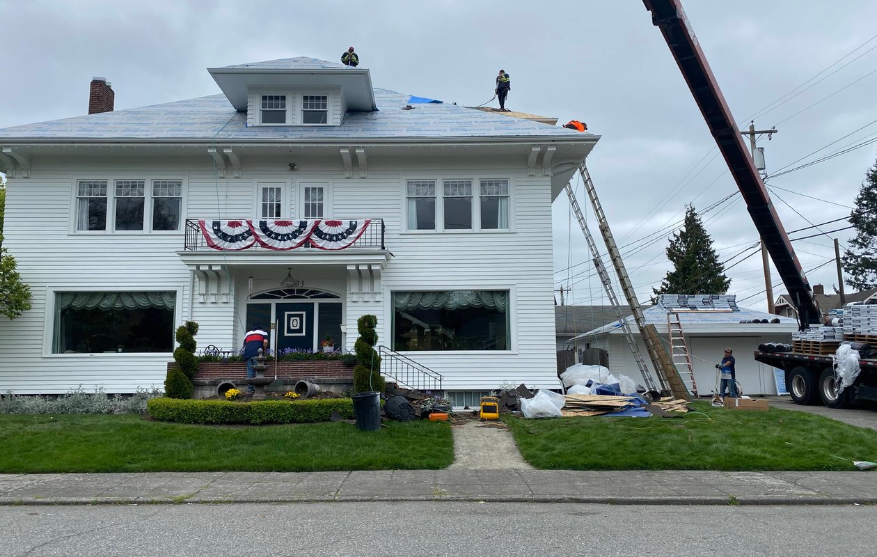 Roofing crane lifting materials for residential roof