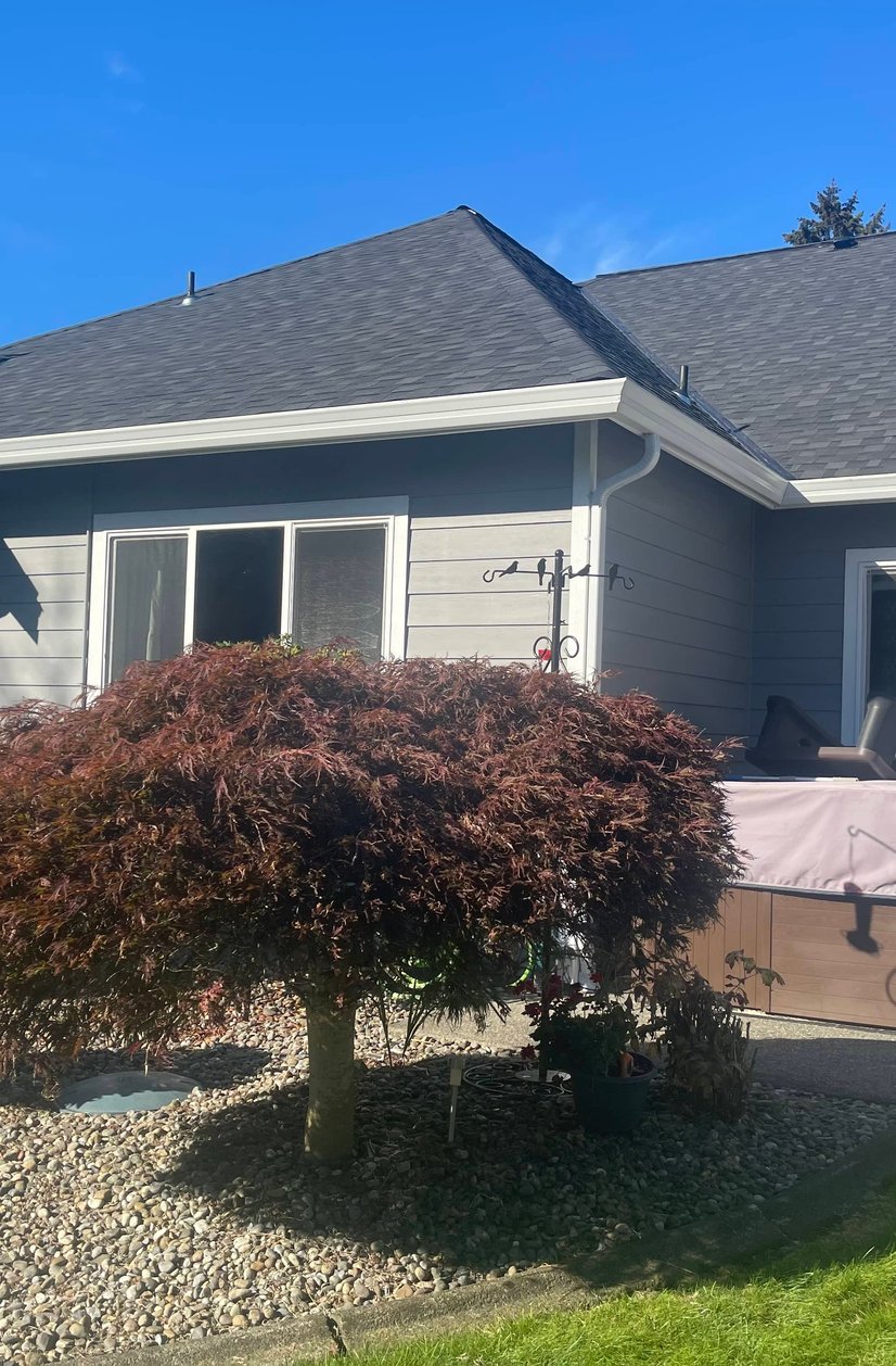 Exterior home renovation showing new roofing work